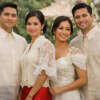 Four people wearing traditional Filipino attire (Barong Tagalog for the men and Filipiniana dresses for the women) posing together at a formal outdoor event or wedding with floral decorations in the background.
