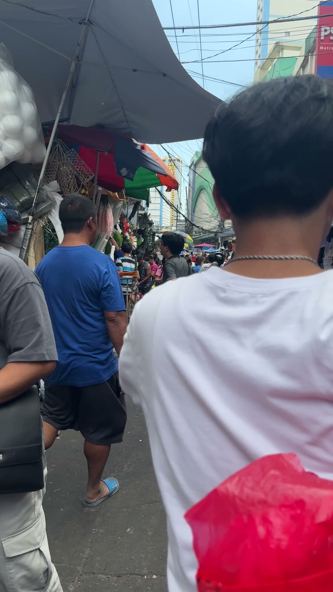 Busy Philippine market street under umbrellas