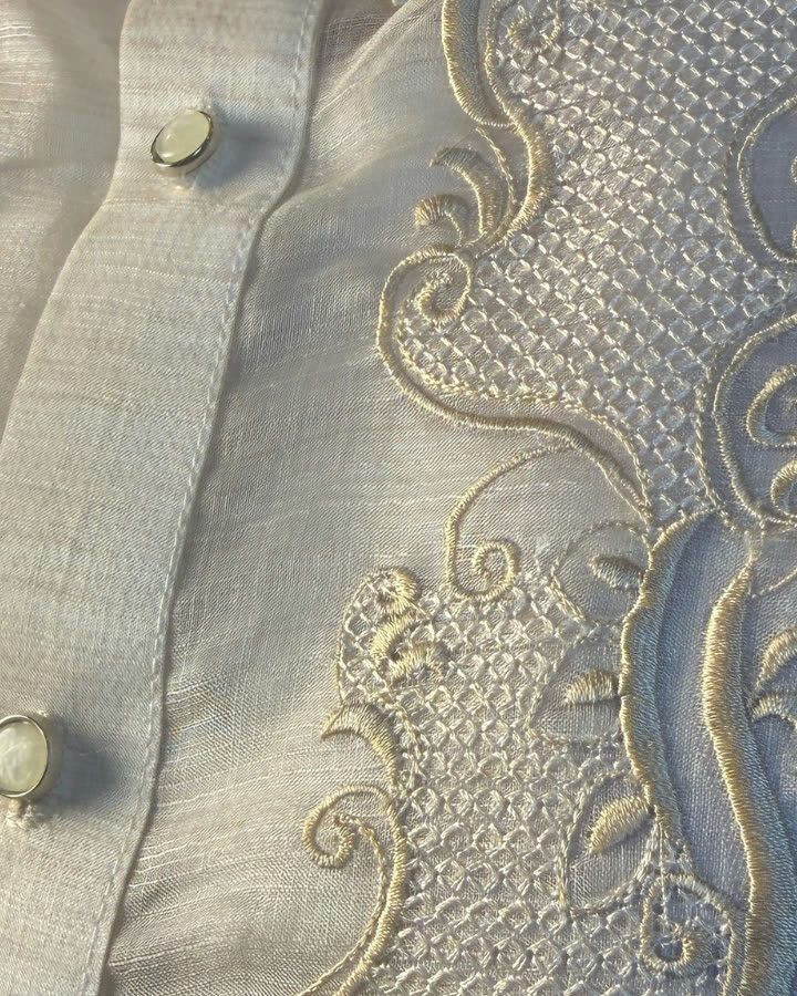 Close-up of hand-embroidered calado panel on a cream barong